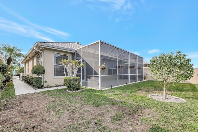 back of property with a yard and a lanai