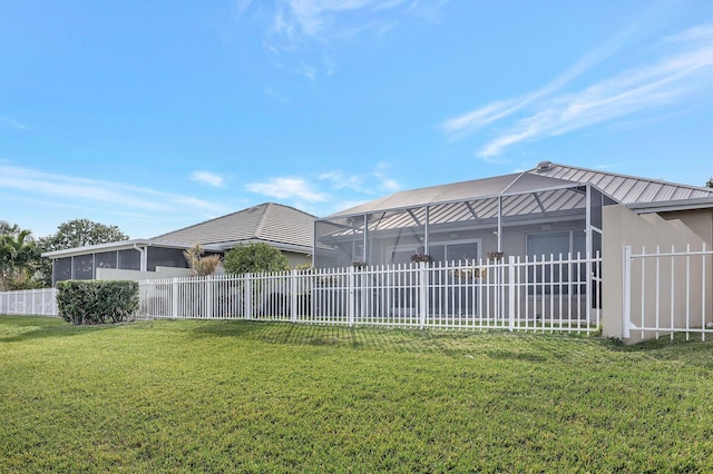 rear view of house featuring a lanai and a yard