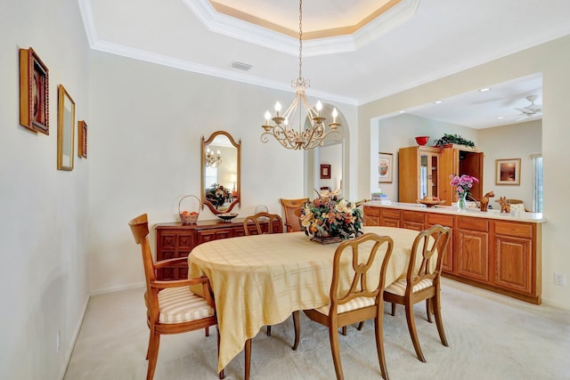 dining space featuring ornamental molding, light carpet, and a tray ceiling