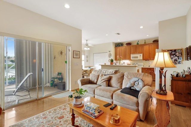 living room with light hardwood / wood-style floors and ceiling fan