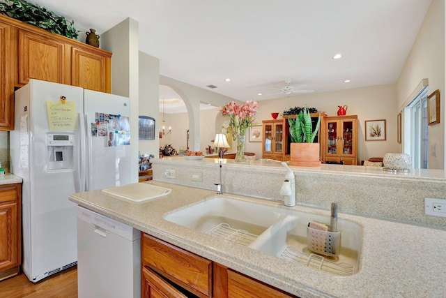 kitchen featuring ceiling fan, sink, white appliances, and light wood-type flooring