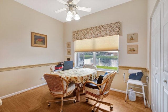 dining room featuring a water view, ceiling fan, and light hardwood / wood-style floors