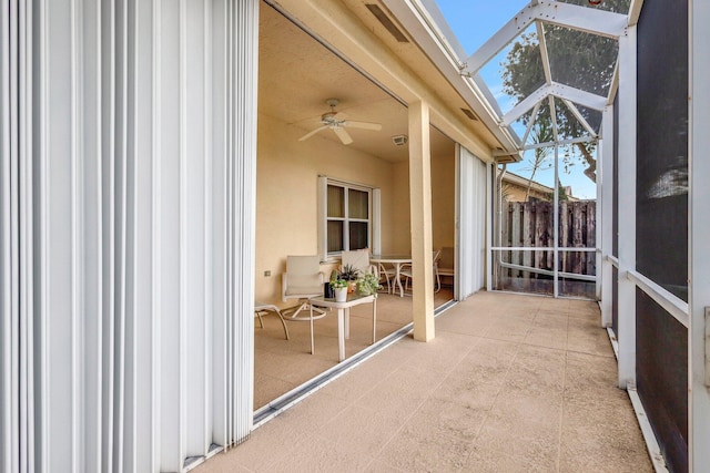 unfurnished sunroom featuring ceiling fan