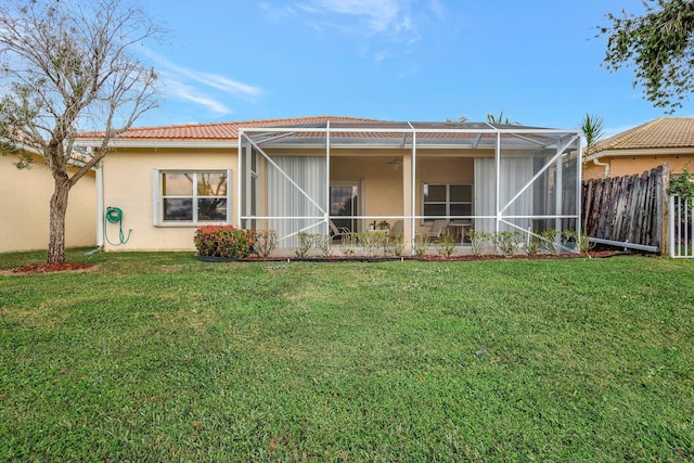 rear view of house with a yard and a lanai