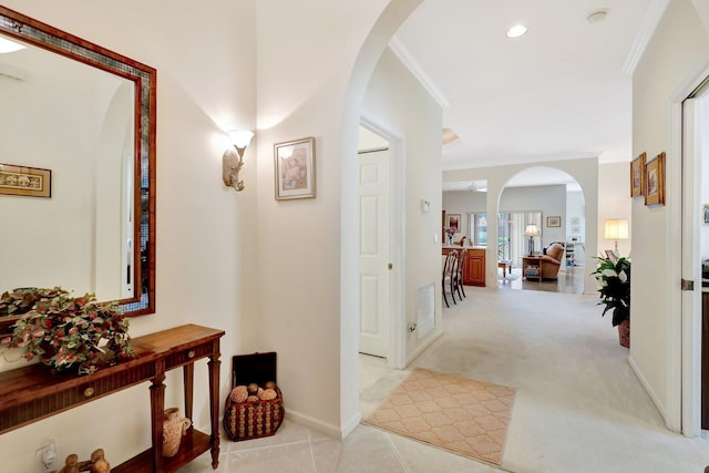 hallway with light colored carpet and ornamental molding