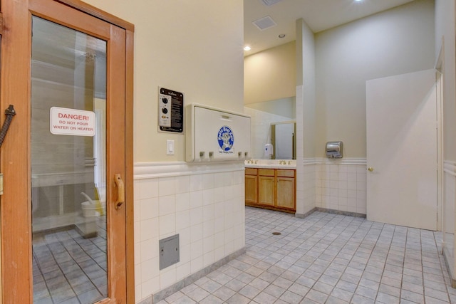 bathroom featuring vanity, a towering ceiling, and tile patterned floors