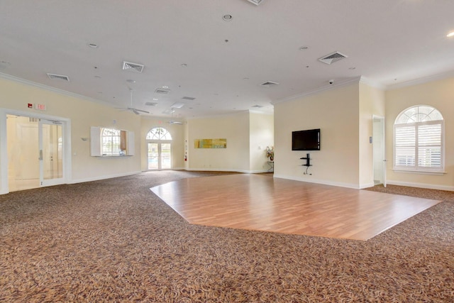 unfurnished living room with ornamental molding and carpet flooring