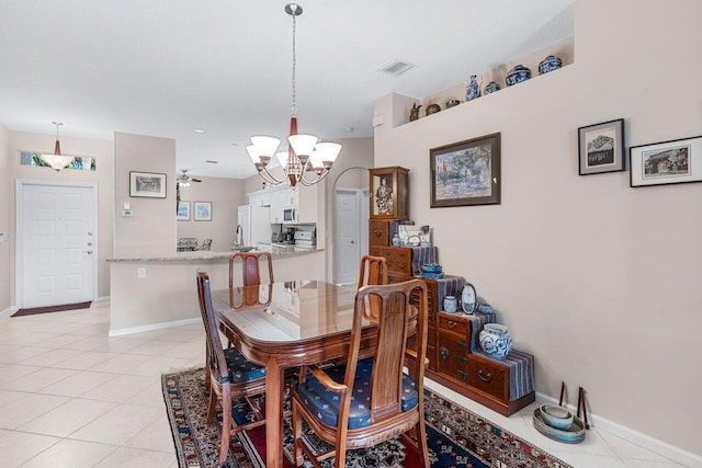 tiled dining area featuring a chandelier