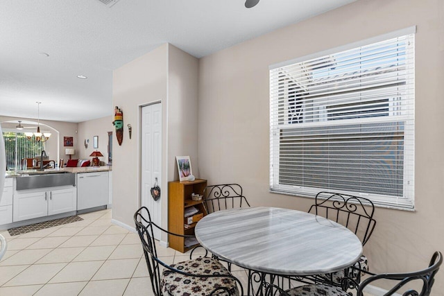 dining space featuring an inviting chandelier, sink, and light tile patterned floors