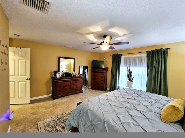 bedroom with light tile patterned flooring, ceiling fan, and a textured ceiling