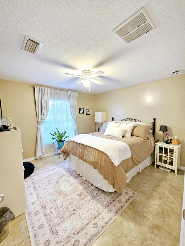 bedroom featuring ceiling fan and a textured ceiling