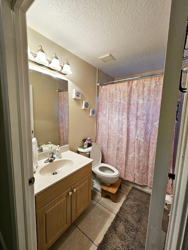 bathroom with tile patterned floors, toilet, a textured ceiling, vanity, and a shower with shower curtain