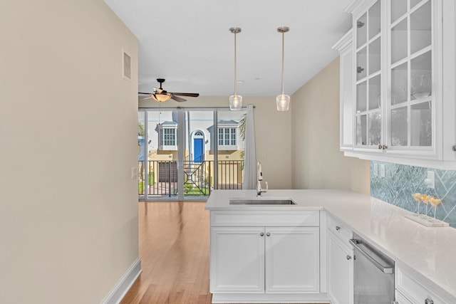 kitchen featuring sink, white cabinets, light hardwood / wood-style floors, and decorative backsplash