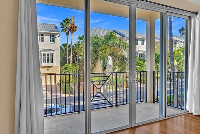 doorway with hardwood / wood-style flooring, a wealth of natural light, and expansive windows