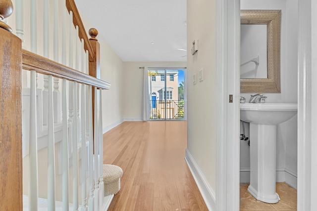 hall with sink and light wood-type flooring