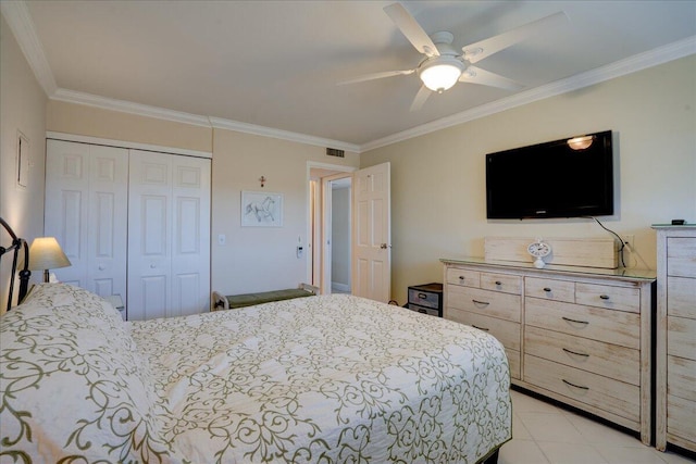 tiled bedroom featuring ornamental molding, ceiling fan, and a closet