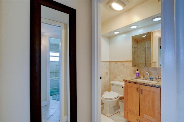 bathroom featuring tile walls, an enclosed shower, vanity, tile patterned floors, and toilet