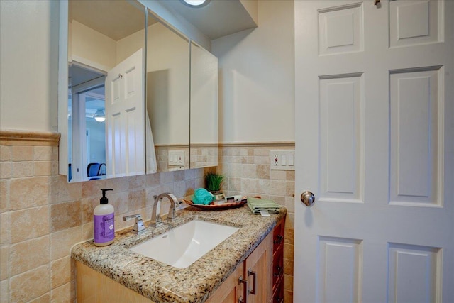 bathroom with vanity and tile walls