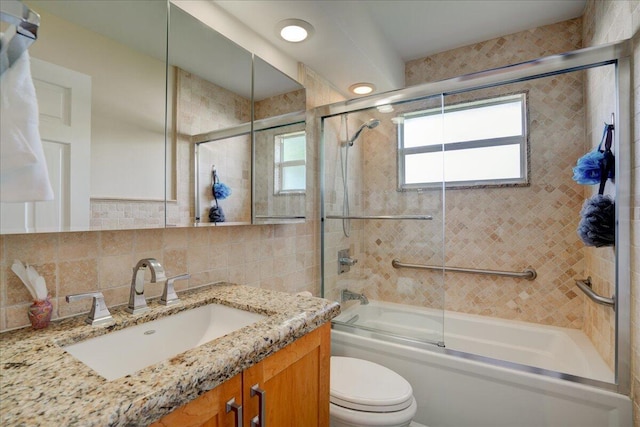 full bathroom with toilet, combined bath / shower with glass door, tasteful backsplash, tile walls, and vanity