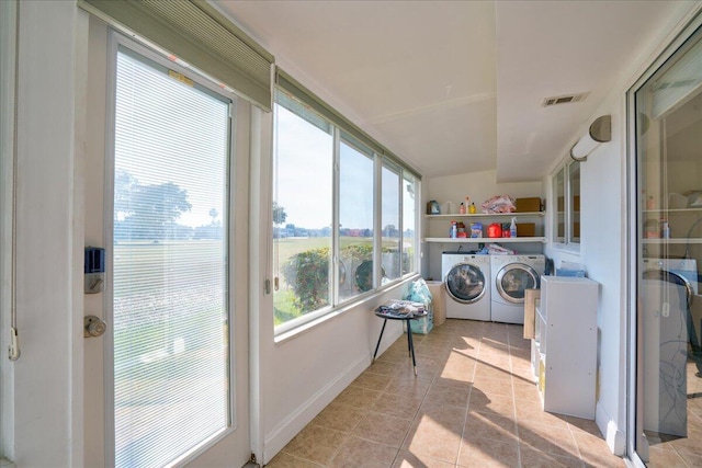 clothes washing area featuring washer and dryer and light tile patterned floors