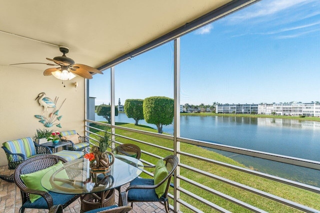 sunroom with a water view and ceiling fan