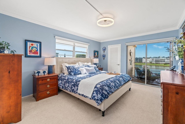 bedroom with multiple windows, access to exterior, light colored carpet, and a water view