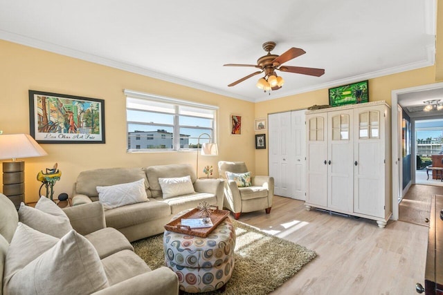 living room featuring crown molding, light hardwood / wood-style flooring, and ceiling fan