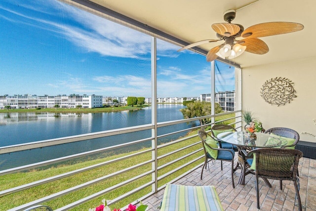 sunroom featuring a water view and ceiling fan