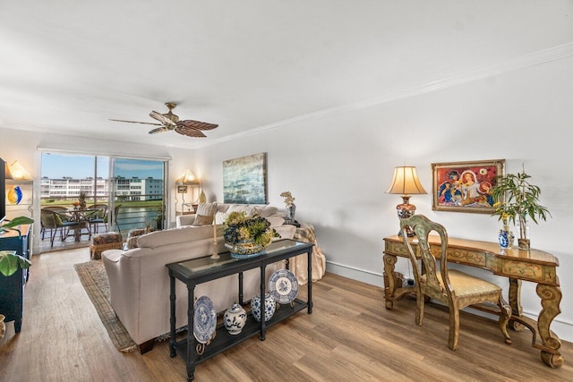 living room with hardwood / wood-style flooring, ceiling fan, and crown molding