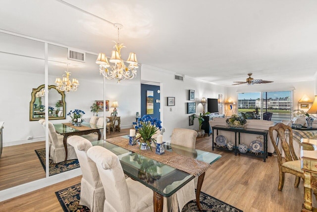 dining room featuring ceiling fan with notable chandelier, ornamental molding, and light hardwood / wood-style floors