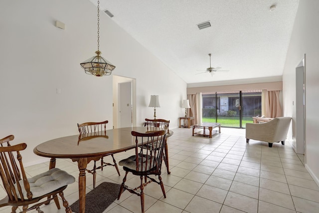 tiled dining space with high vaulted ceiling, a textured ceiling, and ceiling fan