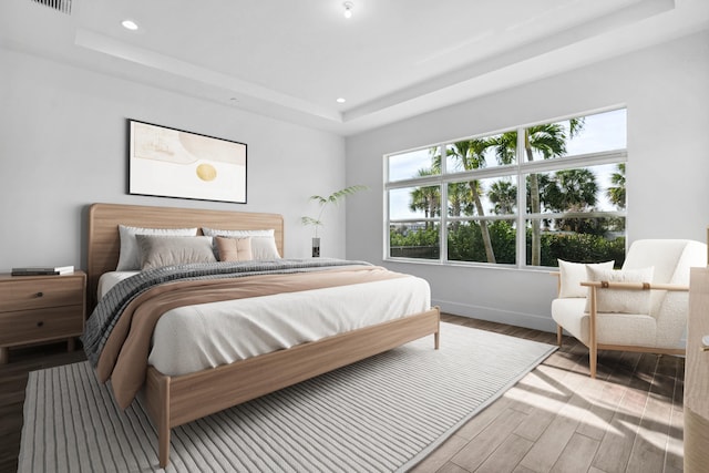 bedroom featuring a raised ceiling and hardwood / wood-style floors