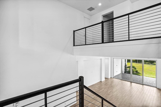 stairs with hardwood / wood-style flooring and a high ceiling