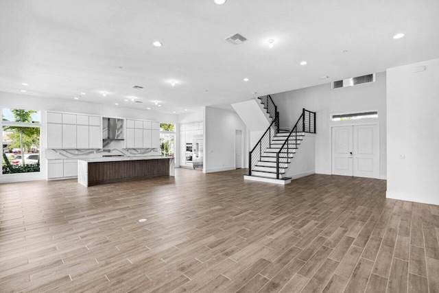 unfurnished living room featuring plenty of natural light and light hardwood / wood-style flooring