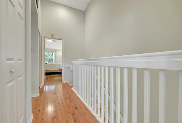 corridor featuring light wood-style flooring and baseboards