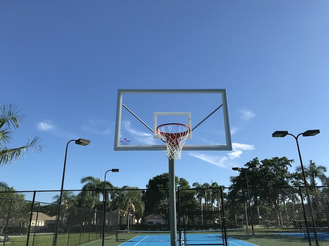 view of sport court with a tennis court and fence