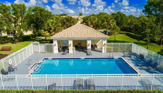 community pool with a patio area and fence