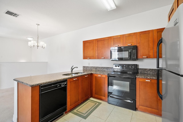 kitchen with decorative light fixtures, kitchen peninsula, sink, and black appliances