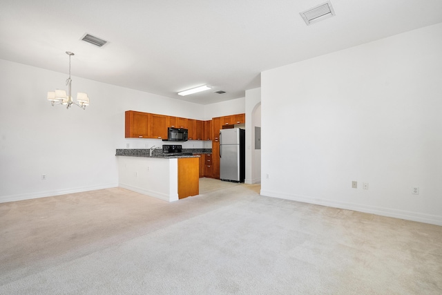 kitchen featuring pendant lighting, light colored carpet, stainless steel refrigerator, and range