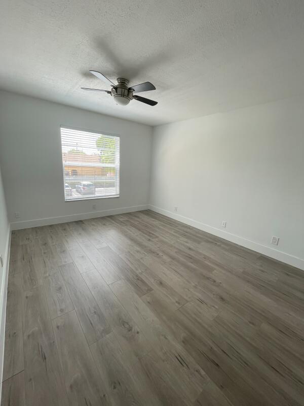 spare room featuring ceiling fan, hardwood / wood-style floors, and a textured ceiling