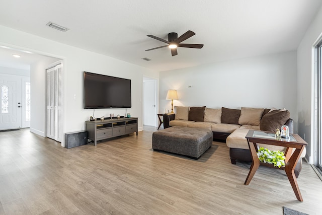 living room with ceiling fan and light hardwood / wood-style flooring