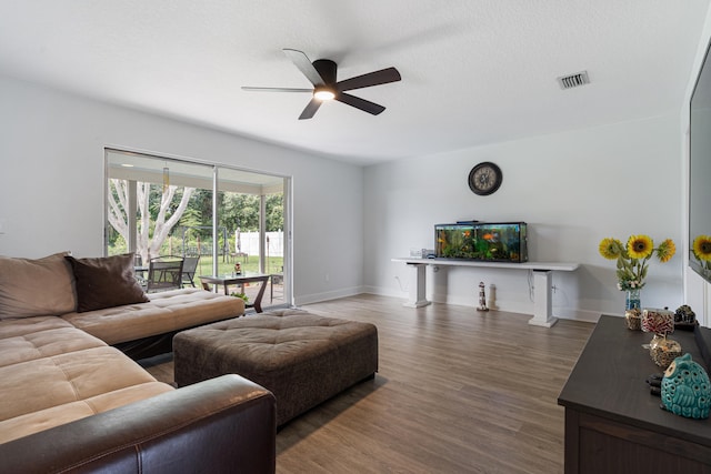 living room with a textured ceiling, dark hardwood / wood-style floors, and ceiling fan