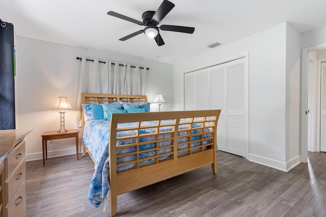 bedroom with a closet, dark hardwood / wood-style floors, and ceiling fan