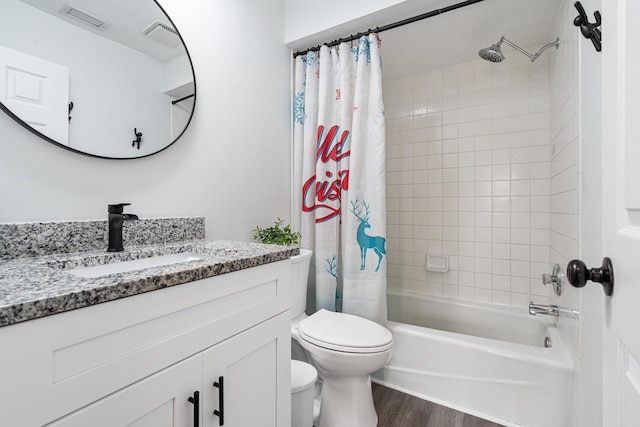 full bathroom with shower / tub combo with curtain, hardwood / wood-style floors, vanity, and toilet