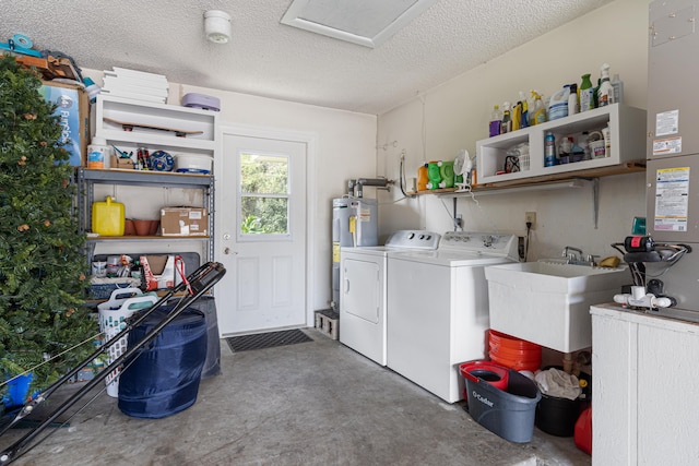 laundry area featuring washer and dryer, sink, water heater, and a textured ceiling