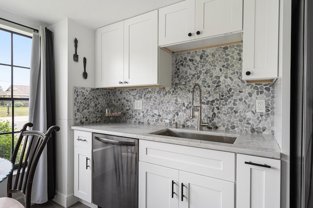 kitchen featuring sink, decorative backsplash, white cabinets, and dishwasher