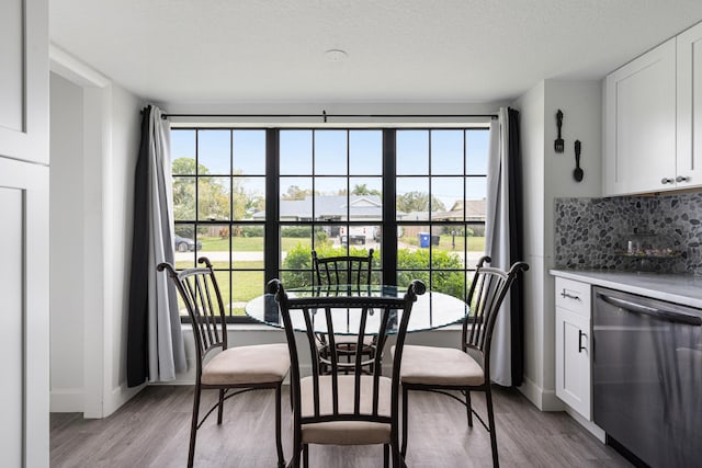 dining space with a textured ceiling, a healthy amount of sunlight, and light wood-type flooring