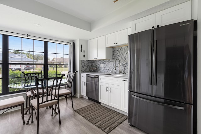 kitchen with white cabinetry, dishwasher, sink, backsplash, and fridge