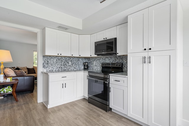 kitchen featuring white cabinetry, electric range oven, decorative backsplash, and light hardwood / wood-style flooring