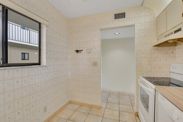 kitchen with mail boxes, white electric range oven, white cabinets, and light tile patterned floors